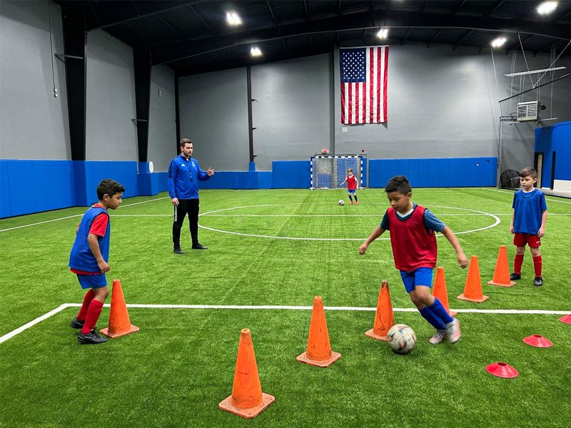 Youth soccer training session with cones and coaching drills